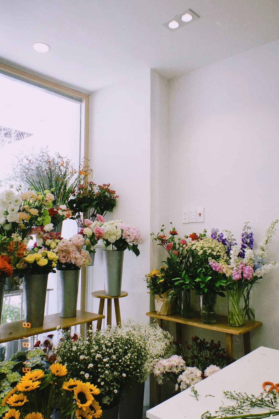 Blomsterhandel med färska snittblommor i hinkar och vaser.